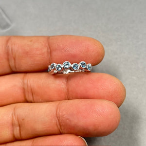 0.77 Ct Swiss Blue Topaz seven stone stack band in 14K white gold featuring seven 3mm round AA natural gemstones in bezel setting. Radiant medium blue December birthstone ring, size 6, elegant stacking band for women with ocean-inspired sparkle. 