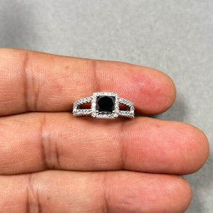 1.50 carat black and white diamond ring in 14K white gold featuring a 1.06 ct princess cut AA black diamond center surrounded by 44 round white diamonds totaling 0.44 ct in prong setting. Rhodium plated band with 2.5–4.2 mm width in size 7.5. Bold statement ring with strong contrast sparkle, designed for women who love modern luxury and elegant fine jewelry with dramatic appeal. 