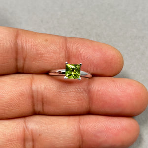 Princess cut natural peridot solitaire ring in 14K white gold featuring a vivid medium green 1.10 ct AAA gemstone in a secure V-prong setting. Rhodium polished gold enhances brilliance, creating a timeless minimalist ring for women with August birthstone elegance and refined everyday jewelry style.
