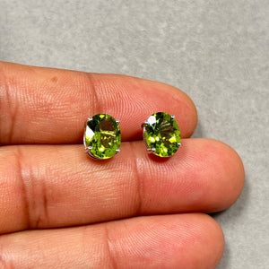 Oval Peridot stud earrings in 18K white gold featuring two natural AAA peridot gemstones, 10x8 mm each, totaling 3.32 carats. The vivid green stones are set in a secure four-prong setting with push back studs. Elegant gemstone earrings designed for women who appreciate refined, minimal gold jewelry with bright natural color. 