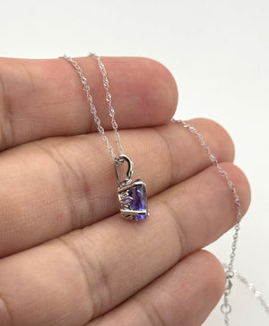 Tanzanite necklace flat lay with polished platinum detail and classic sophisticated styling