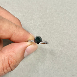 Flat lay of 14K White Gold engagement ring with natural black diamond on luxury styling props 