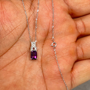 Elegant 14K White Gold pendant featuring a natural 7x5 mm barrel-cut Amethyst (0.90–0.95 Ct) accented with 0.04 Ct round Diamonds, hanging on an 18-inch Singapore chain. Perfect for adding violet sparkle to daily wear or evening attire, combining timeless elegance with fine craftsmanship for women who appreciate luxury jewellery. 