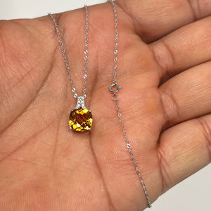 AAA natural citrine and diamond filigree pendant crafted in 14K white gold, featuring a cushion checkerboard-cut citrine (1.87–2.44 Ct) with radiant golden tones. Accented by two round diamonds (0.04 Ct, H color SI clarity) in prong setting, paired with an 18-inch Singapore chain. Elegant fine jewelry piece designed for women who appreciate timeless craftsmanship and warm gemstone brilliance. 
