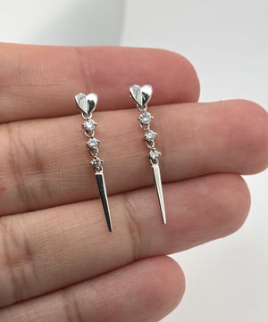 Diamond earrings size reference on hand showing delicate drop proportions