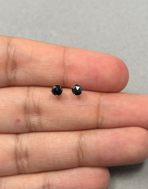 Round rose cut black diamond stud earrings crafted in solid 18K yellow gold, featuring two AAA quality black diamonds totaling approximately 0.48–0.60 carats, secured in classic four prong settings with push back closures for everyday wear. 