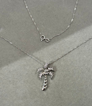14K white gold palm tree pendant necklace featuring 15 round white diamonds in prong setting, SI2–I1 clarity and I–J color, total weight 0.12–0.17 carats, paired with an 18 inch Singapore chain for women. 