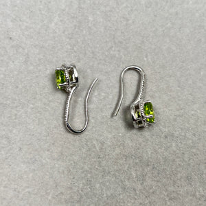 Shop 2.70ct Peridot & Diamond Halo Earrings at Instagem. Solid 14K White Gold studs featuring vibrant round green gemstones. The perfect August birthstone.