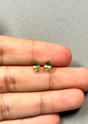 Natural oval Peridot stud earrings in 14K yellow gold, featuring AAA quality 6x4 mm green peridot gemstones in classic four prong settings with push backs, approx 0.74 carat total weight, elegant August birthstone earrings for women with vibrant fresh green sparkle. 