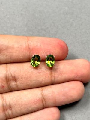 Oval Peridot Stud Earrings in 14K White Gold featuring AAA quality natural peridot gemstones (8x6 mm each) with a vivid medium green hue. These 2.75–2.85 carat earrings are set in a classic four-prong setting with rhodium finish and secure push backs, offering elegant sparkle and timeless gemstone jewelry style. 
