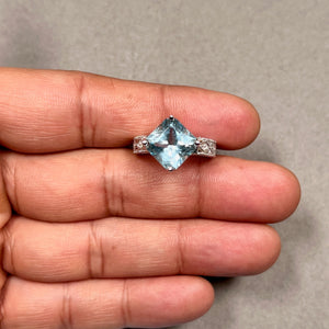 Radiant cut 4.90 Ct AAA aquamarine ring in 14K white gold with rhodium finish, featuring medium blue gemstone and four round diamonds totaling 0.04 Ct in secure prong setting, size 7 women ring with clean polished band and balanced modern design. 