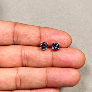 Alexandrite earrings showing color shift under warm light