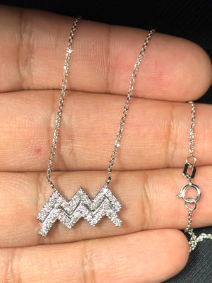 Close-up view of a finely crafted Aquarius zodiac pendant in 14K white gold with rhodium finish, featuring forty round prong-set diamonds arranged in a structured constellation-style formation. The design measures approximately 0.40 inches in height and 0.82 inches in width, paired with an 18-inch cable link chain. The SI2–I1 clarity and I–J color diamonds create a subtle, balanced sparkle suitable for refined everyday wear. 