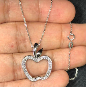 Diamond apple pendant in 14K white gold featuring 35 round diamonds in prong settings, SI2–I1 clarity and I–J colour. Apple-shaped design measuring 0.97 x 0.77 inches with a rhodium finish for added shine. Includes an 18-inch Singapore chain with spring-ring clasp, offering a lightweight and structured jewellery piece for women. 