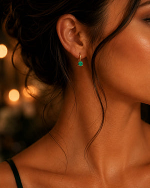 Woman wearing petite emerald earrings with elegant evening styling for anniversary jewelry inspiration