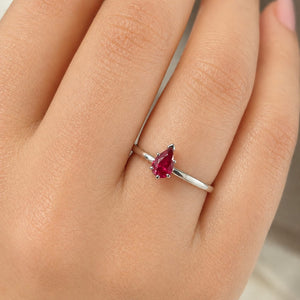 Woman wearing delicate ruby solitaire ring styled for anniversary occasion