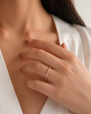 woman wearing slim rose gold band on finger styled for wedding or everyday wear