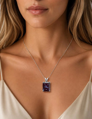 AAA Lab Created Alexandrite scroll solitaire pendant in 14K White Gold with a 16x12 mm emerald cut gemstone.