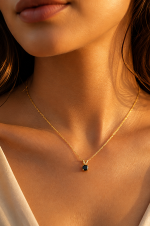Black diamond pendant worn at neckline on 18-inch 14K yellow gold black diamond necklace 